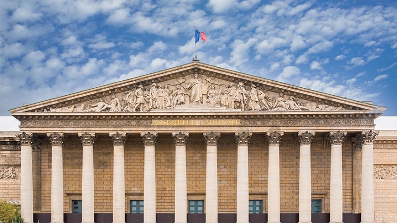 Photo of Assemblée nationale in Paris against a blue sky.