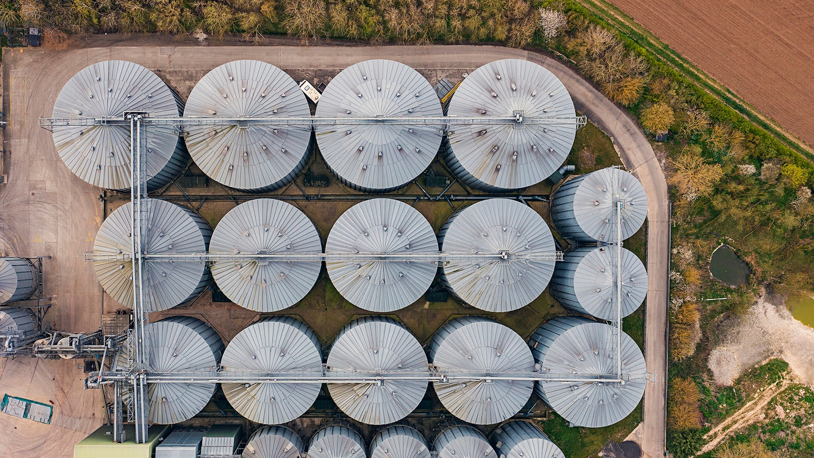 An aerial image of grain silos next to a field.