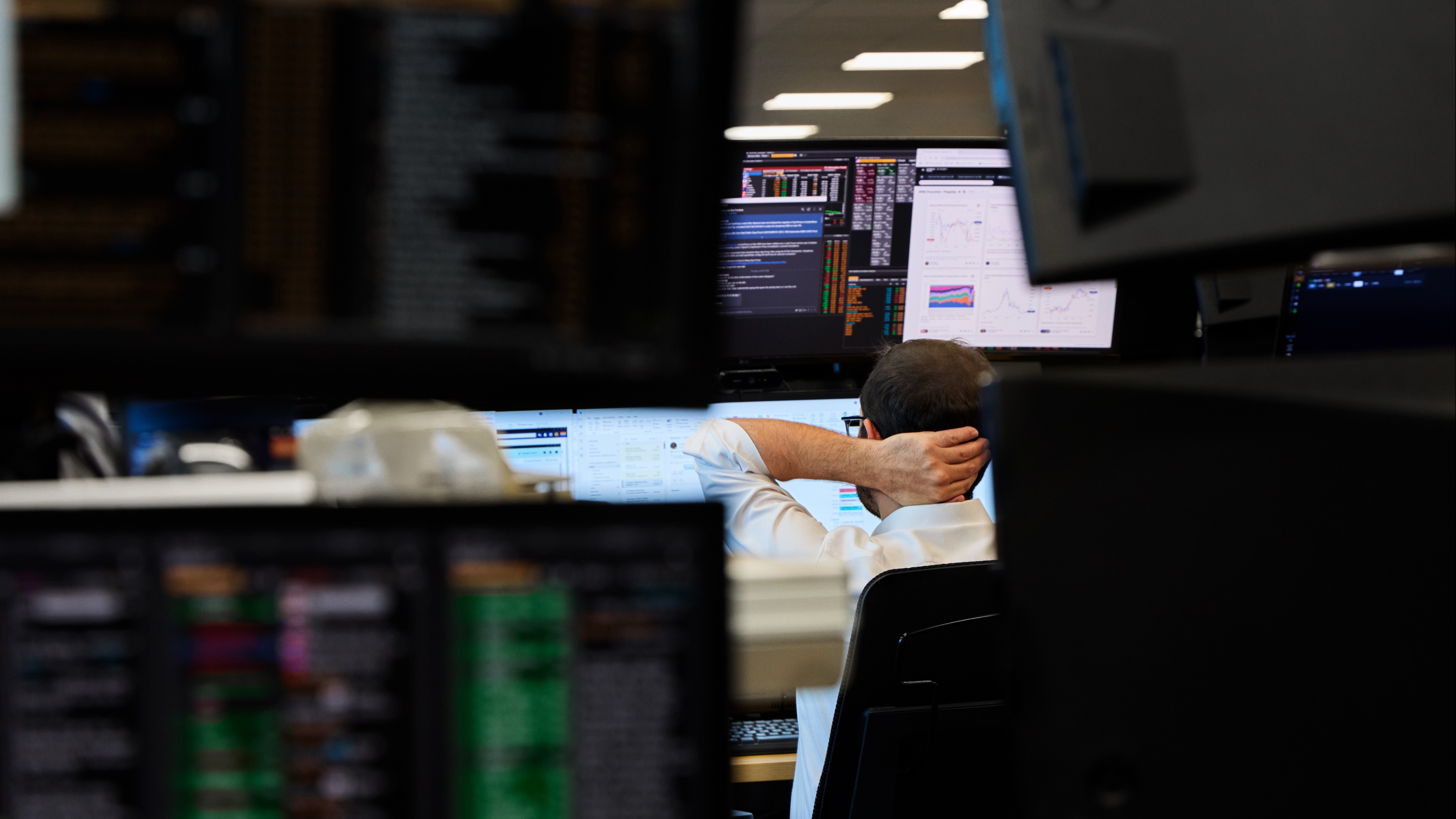 A bank worker looks at monitors.