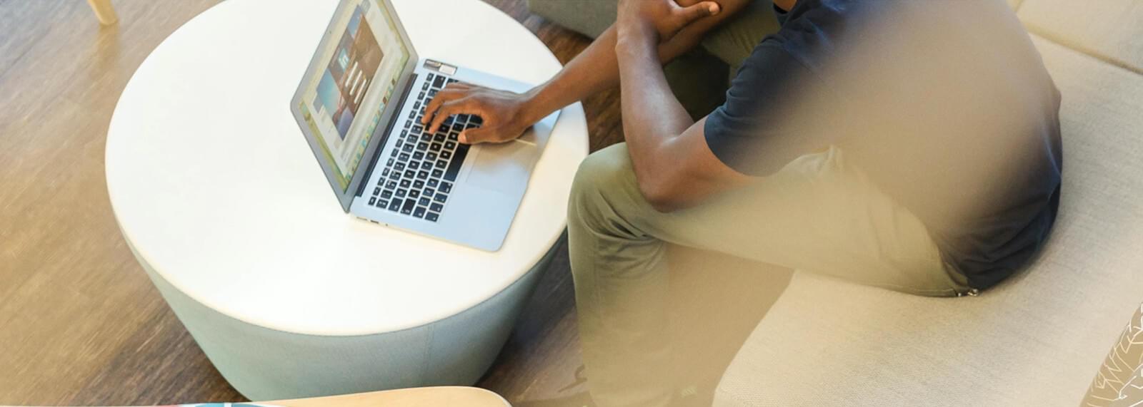 Cropped image of man typing on laptop keyboard.